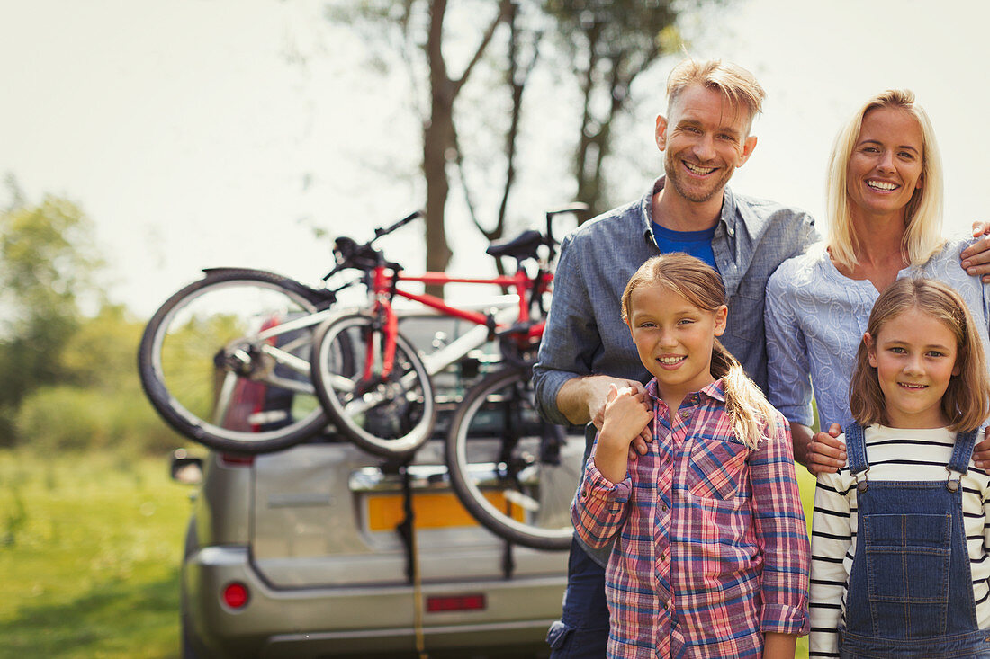 Portrait family near car with mountain bikes