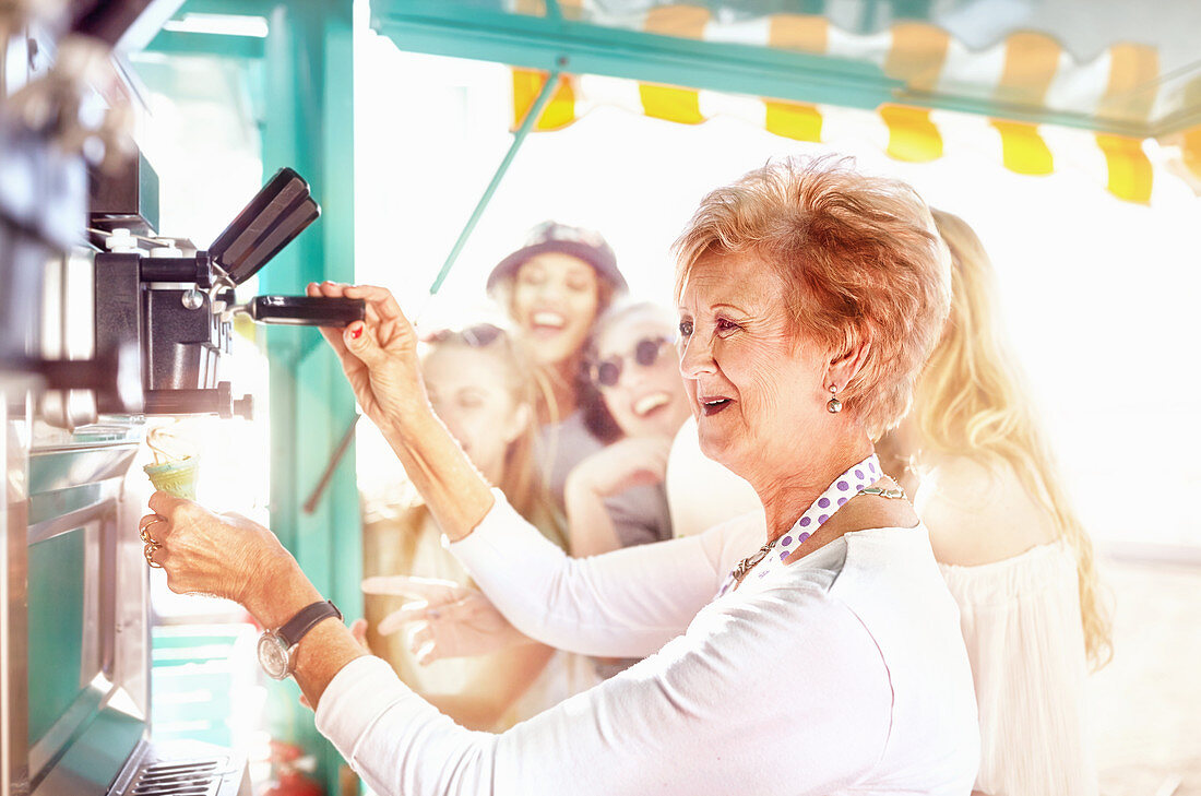 Senior female business owner serving ice cream