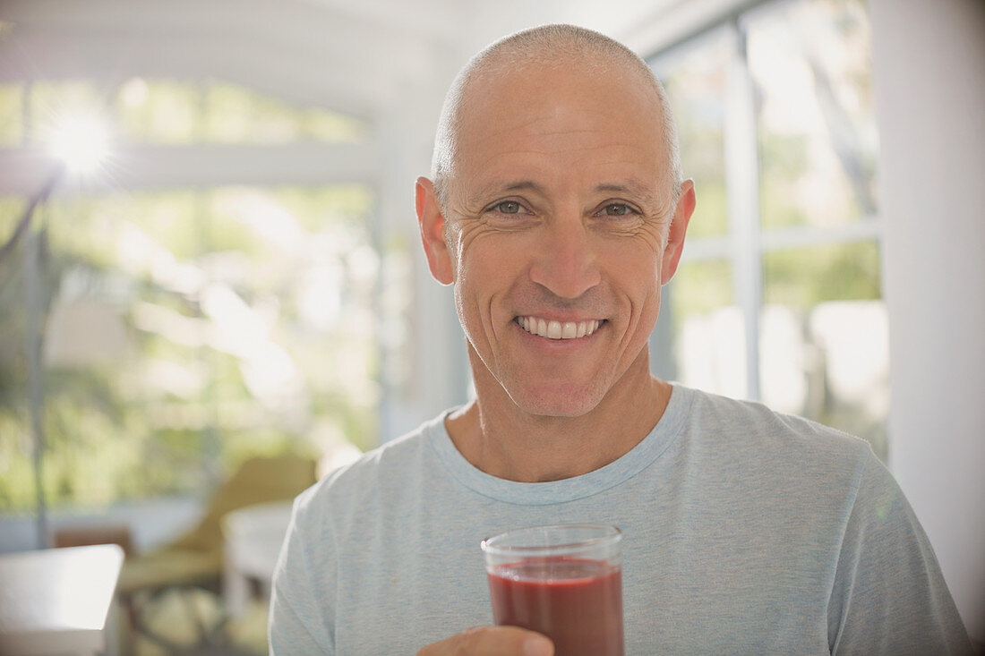 Mature man drinking healthy fruit smoothie