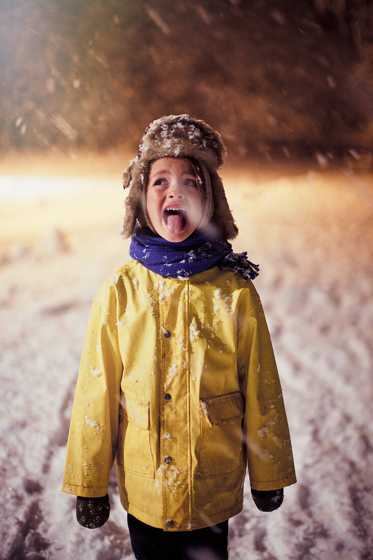 Boy sticking tongue out, tasting snow