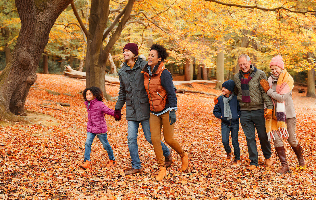 Multi-generation family walking in autumn park