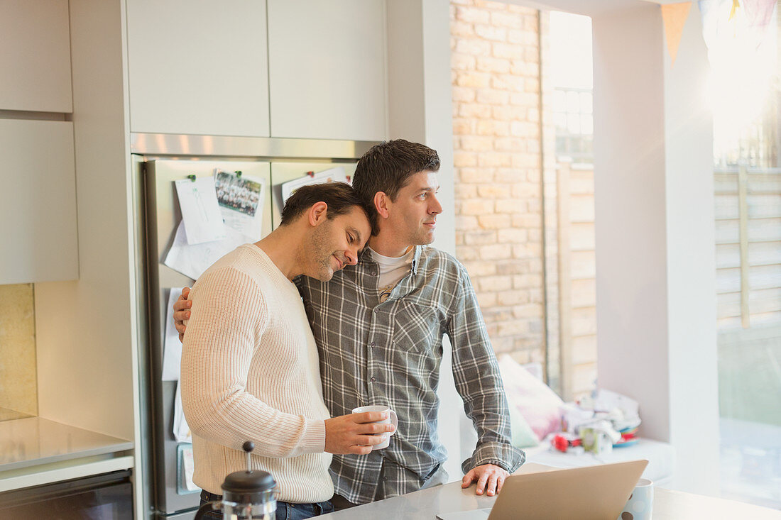 Affectionate male gay couple with coffee