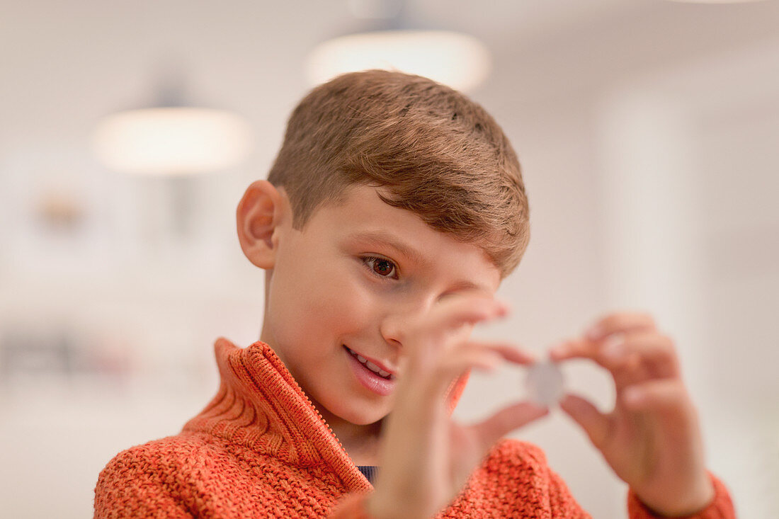 Curious boy holding coin