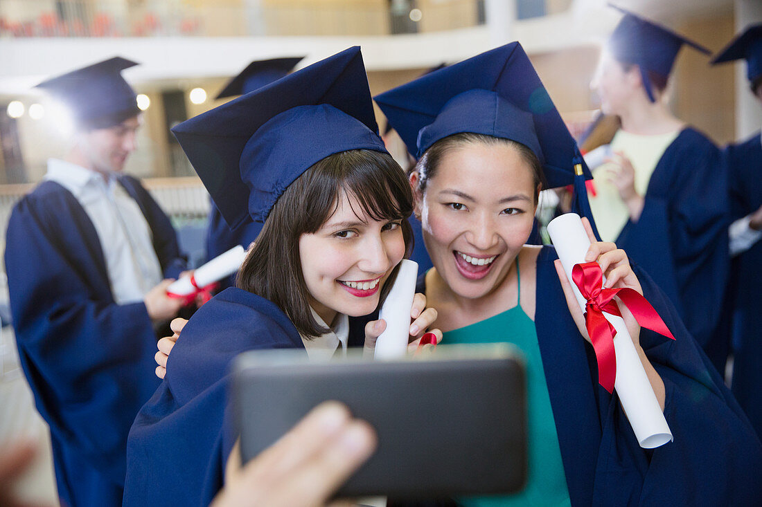 Female college graduates taking selfie