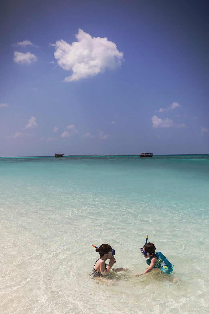 Brother and sister snorkelling in ocean