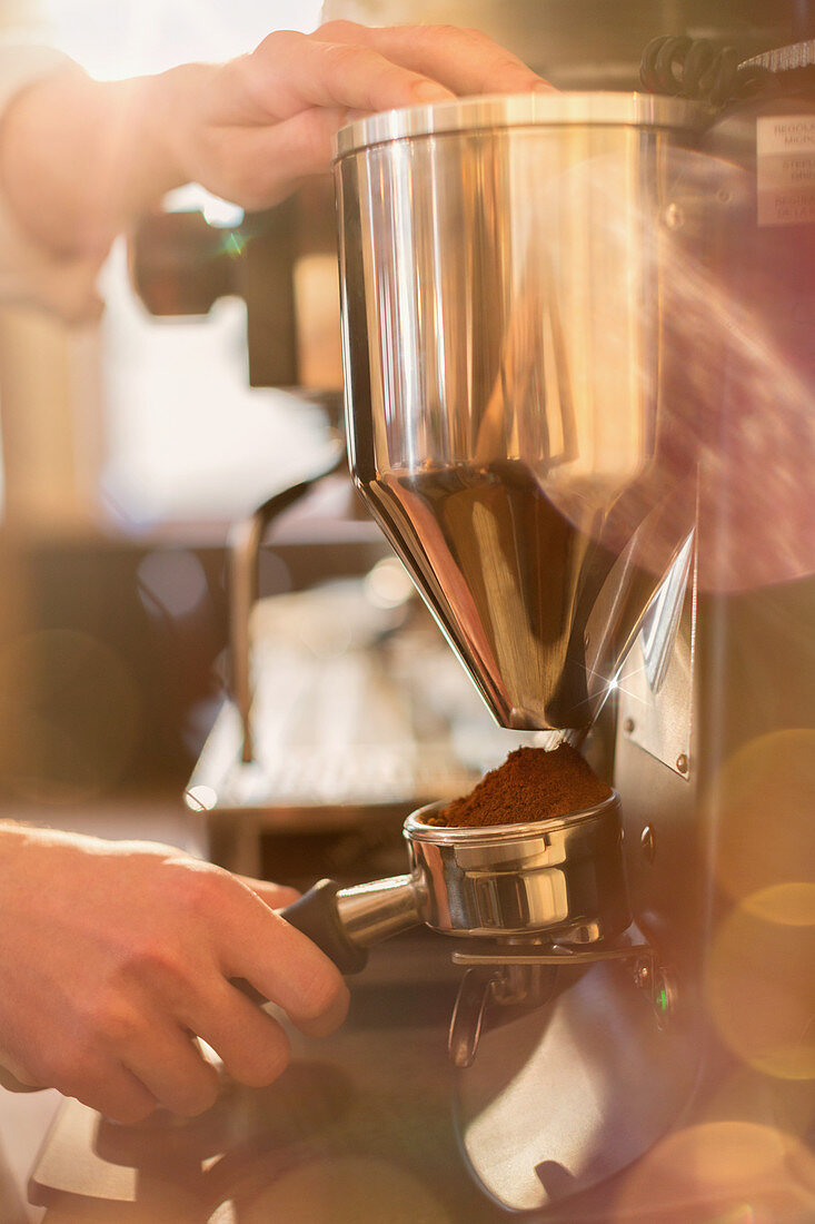 Close up barista using espresso machine grinder