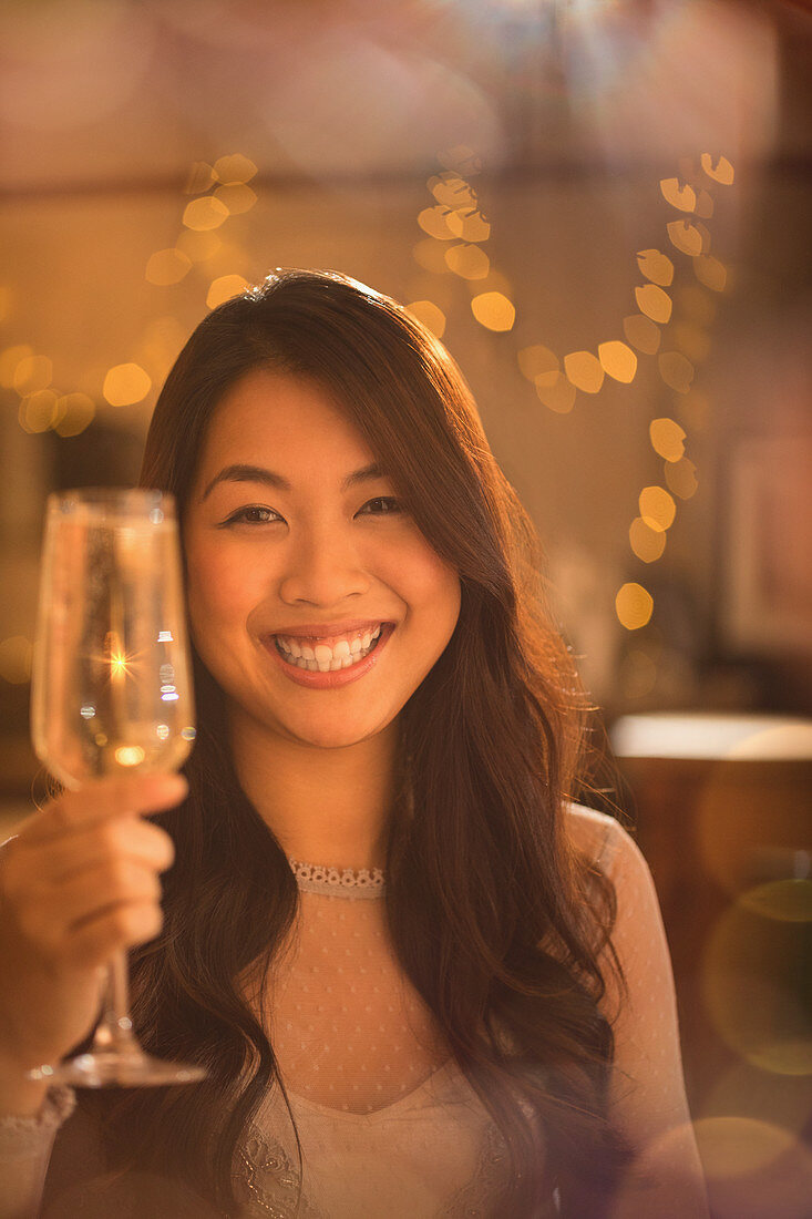 Portrait Chinese woman toasting champagne flute