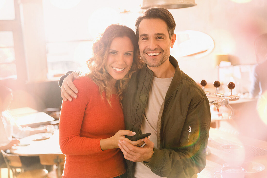 Portrait affectionate couple using cell phone