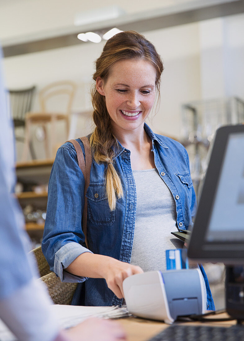 Smiling woman using credit card reader