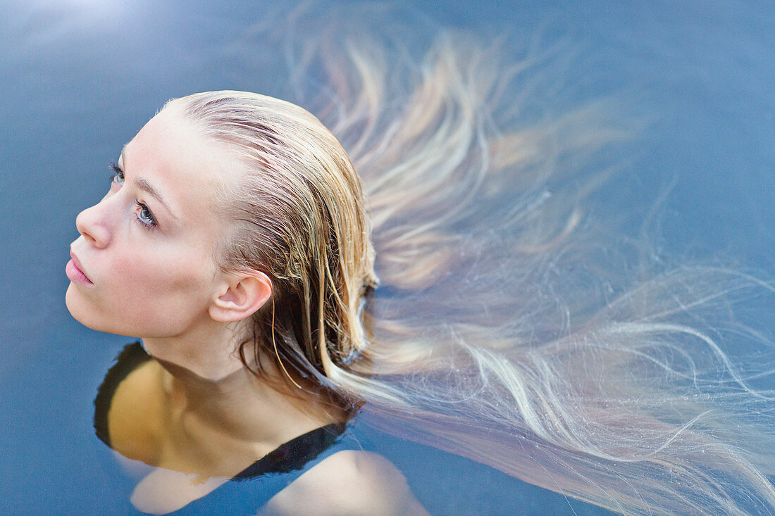 Blonde teenage girl with long hair floating