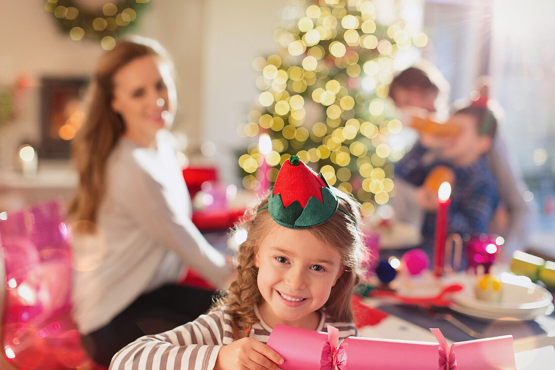 Girl holding Christmas cracker at dinner table