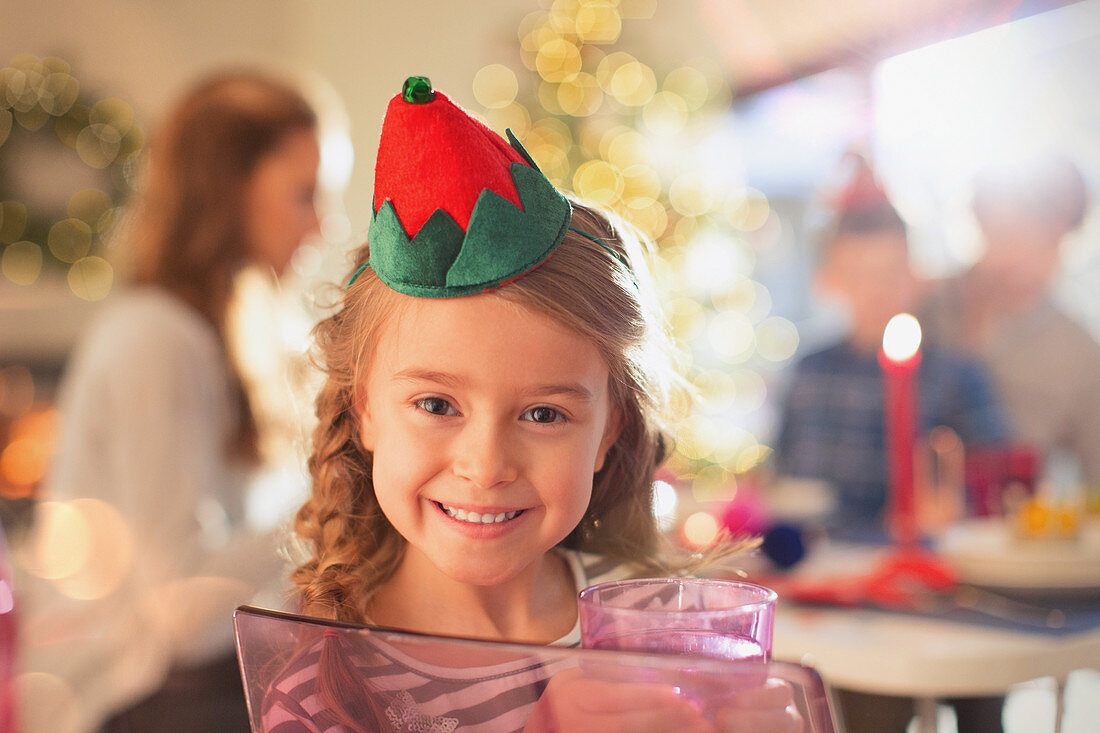 Smiling girl wearing Christmas paper crown
