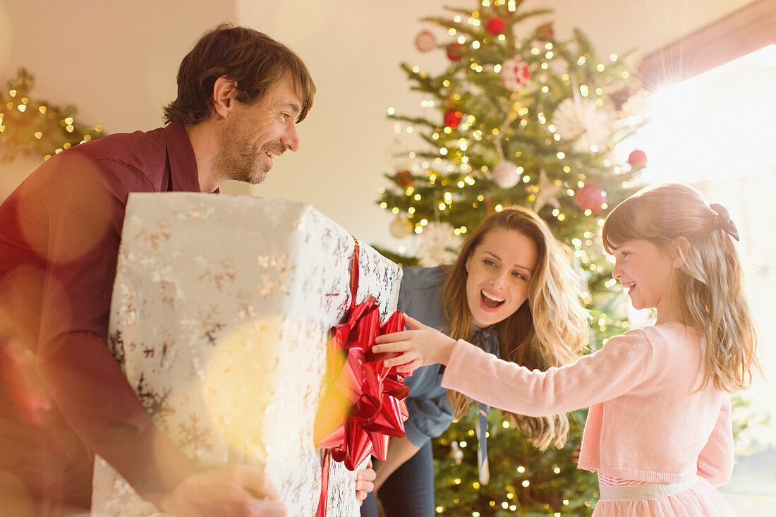 Parents giving Christmas gift to daughter