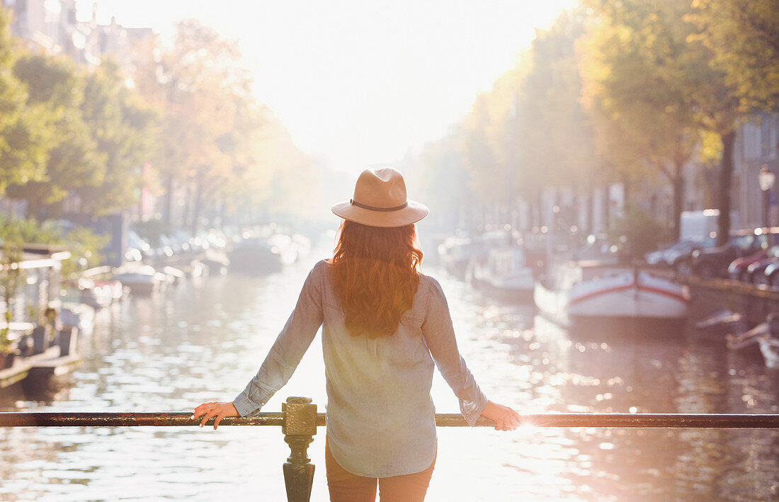 Woman wearing hat looking at autumn canal view