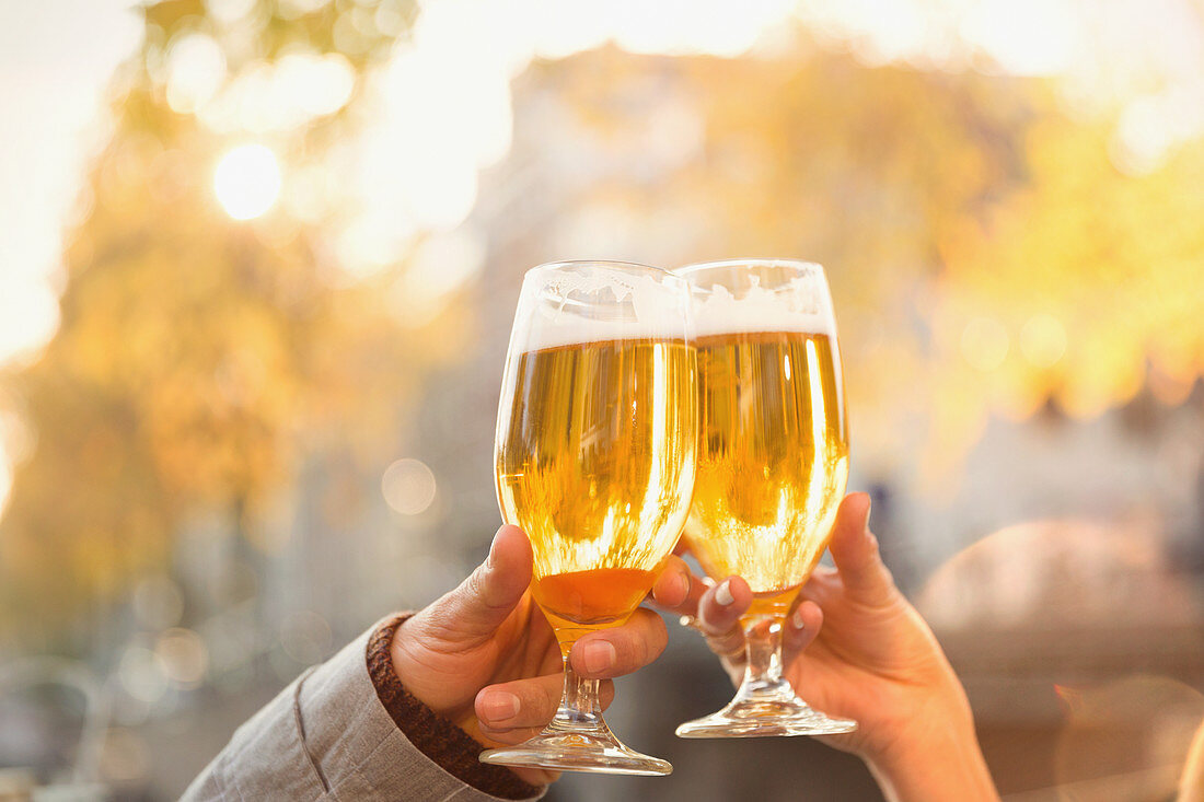Couple toasting beer glasses at autumn cafe