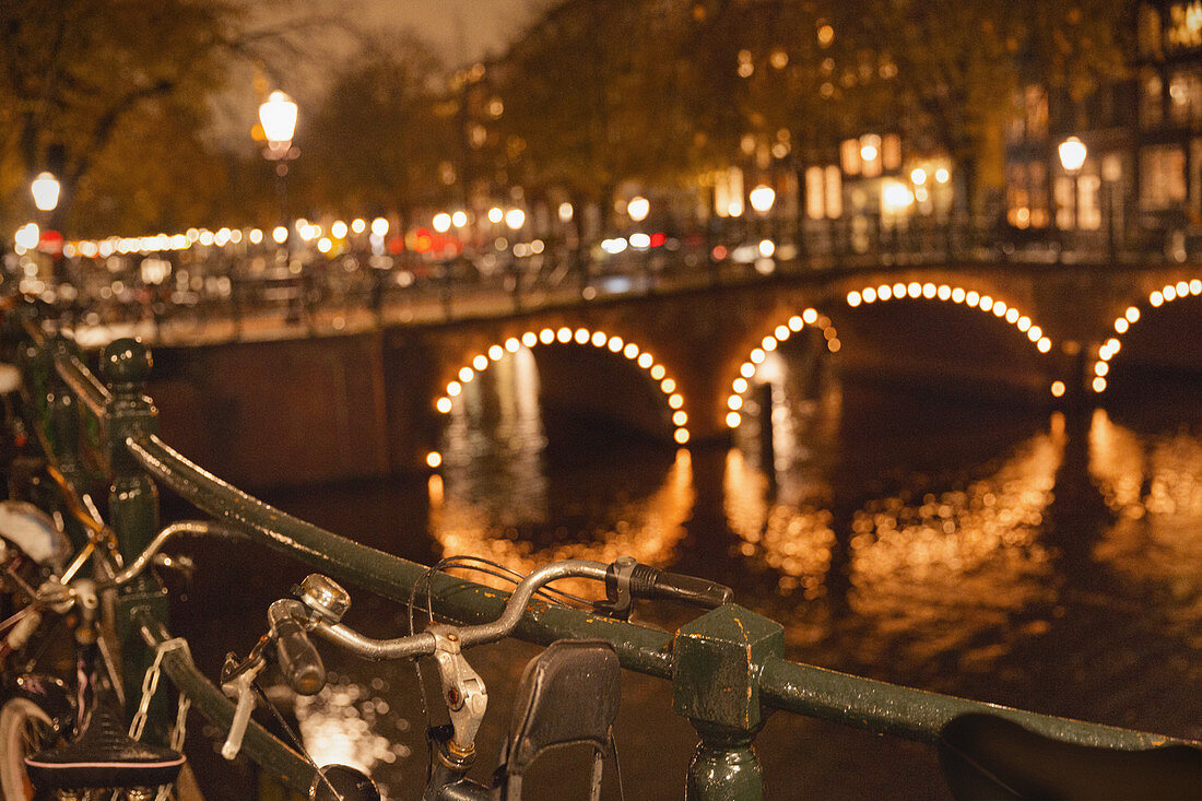 Bicycles and fairy lights along bridge at night