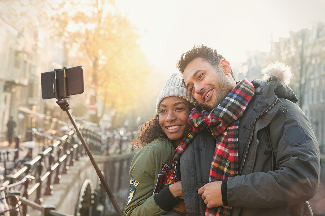 Affectionate couple hugging and taking selfie