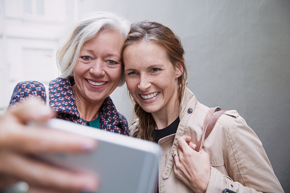 Smiling mother and daughter taking selfie