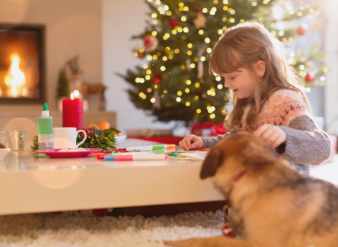 Dog and girl colouring in Christmas living room