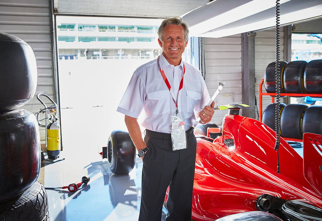 Formula one manager next to race car