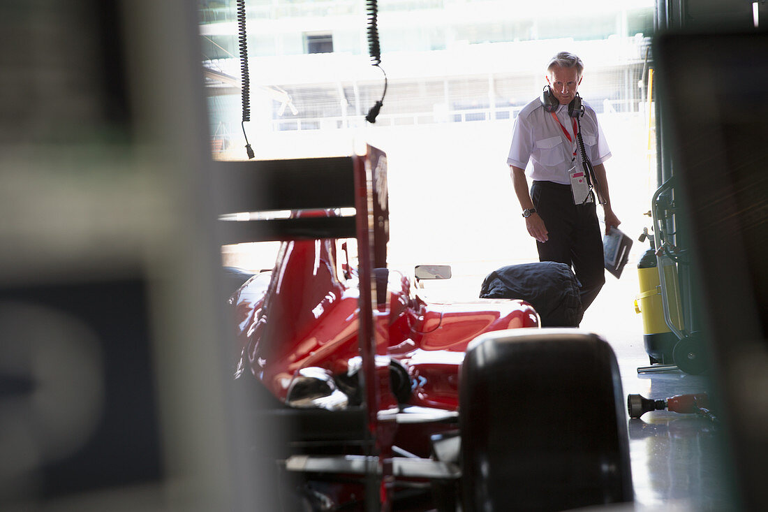 Manager examining formula one race car