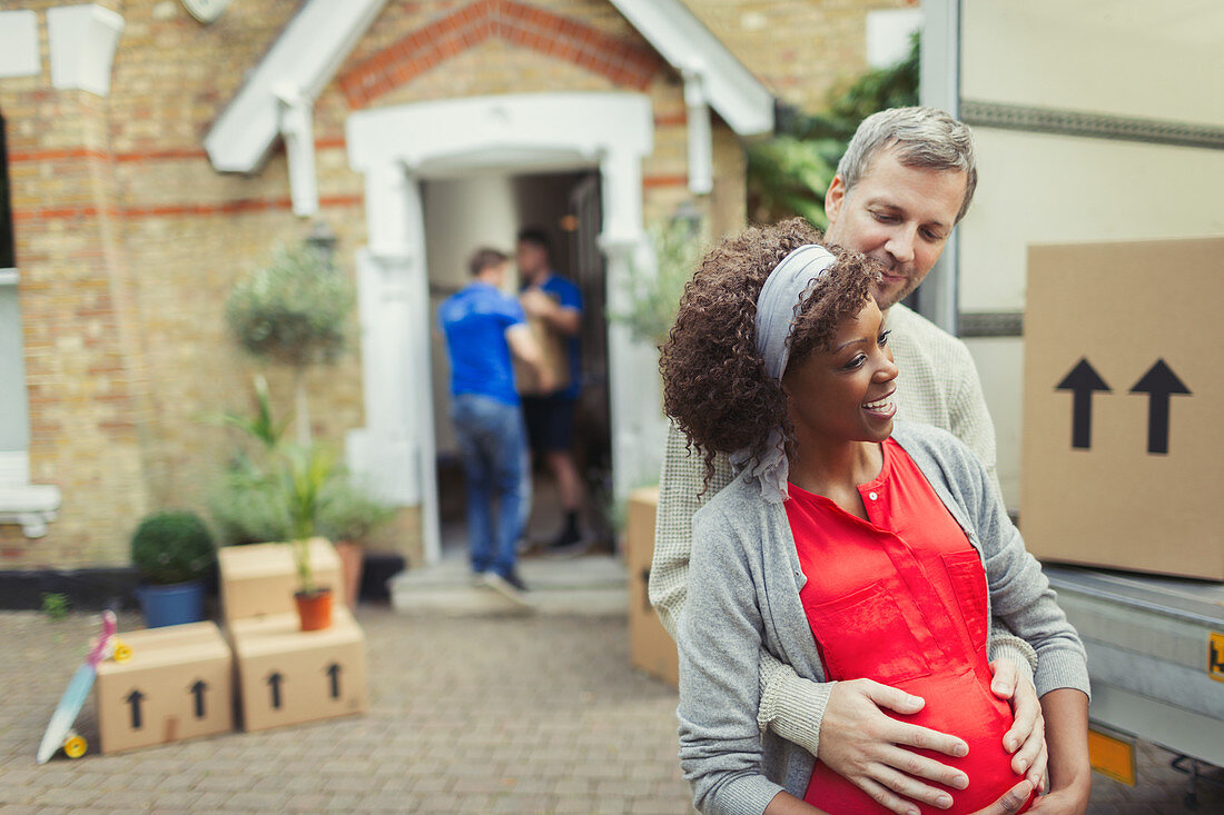 Multi-ethnic pregnant couple moving into new house