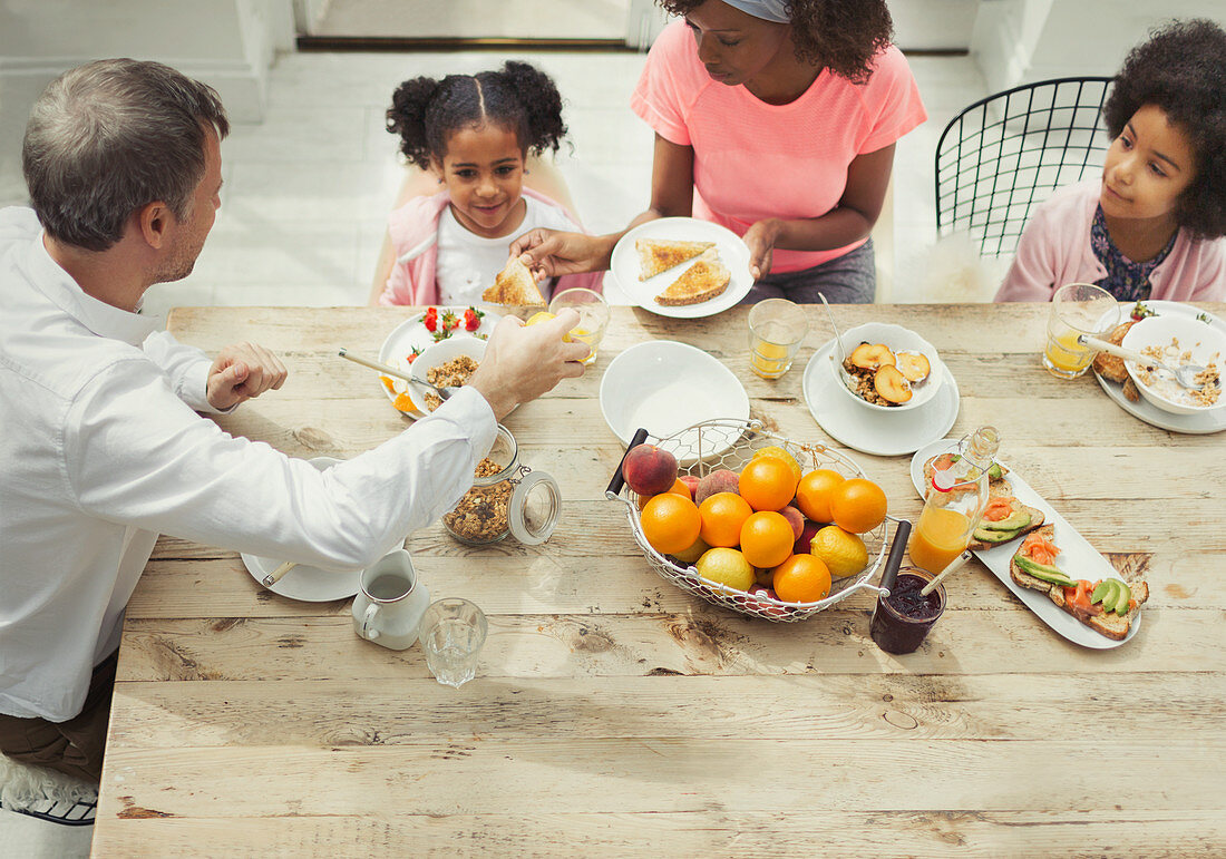 Multi-ethnic family eating breakfast at table