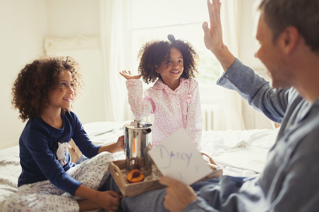 Father receiving Father's Day card from daughters