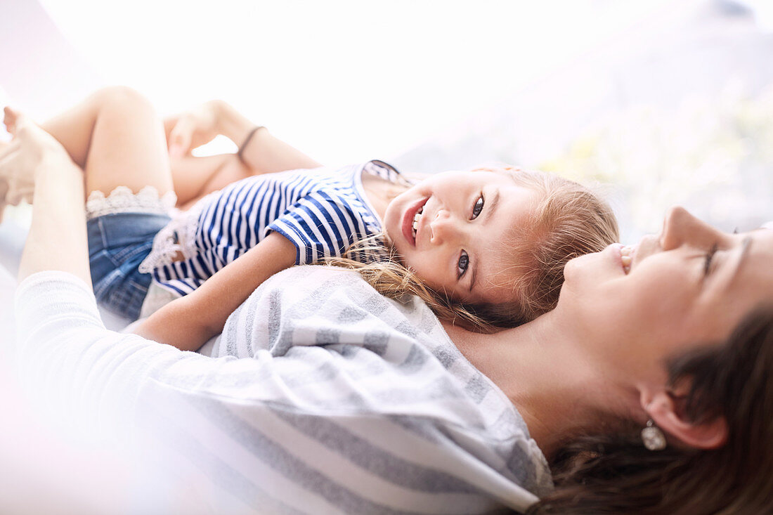 Portrait daughter laying on top of mother