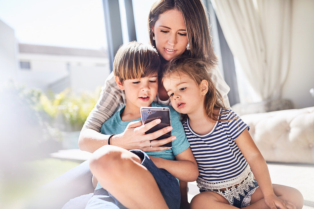 Mother and children using cell phone
