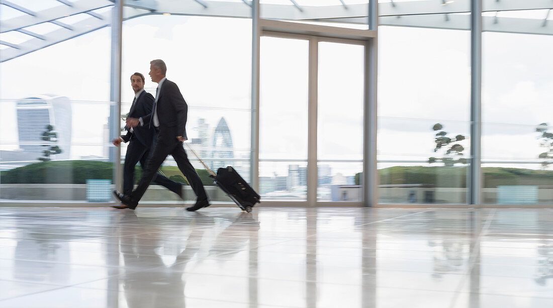 Businessmen pulling suitcase in airport