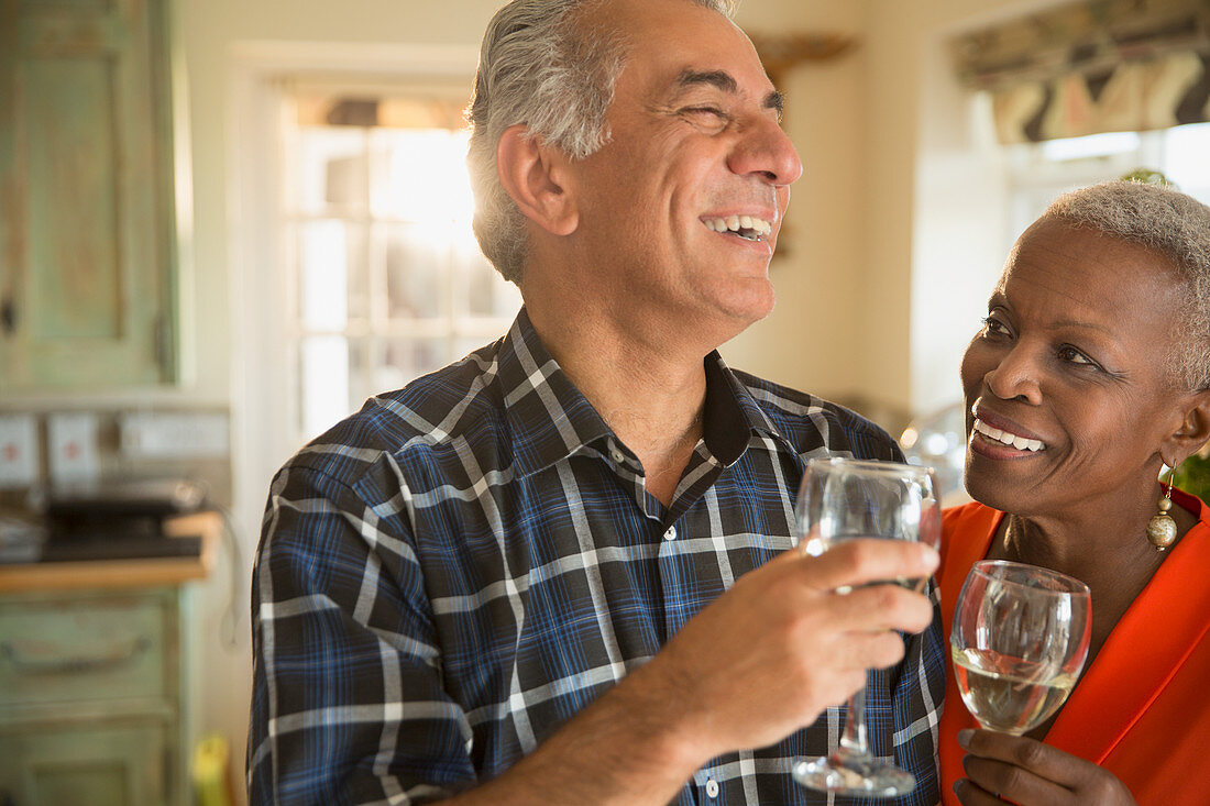 Laughing senior couple drinking white wine