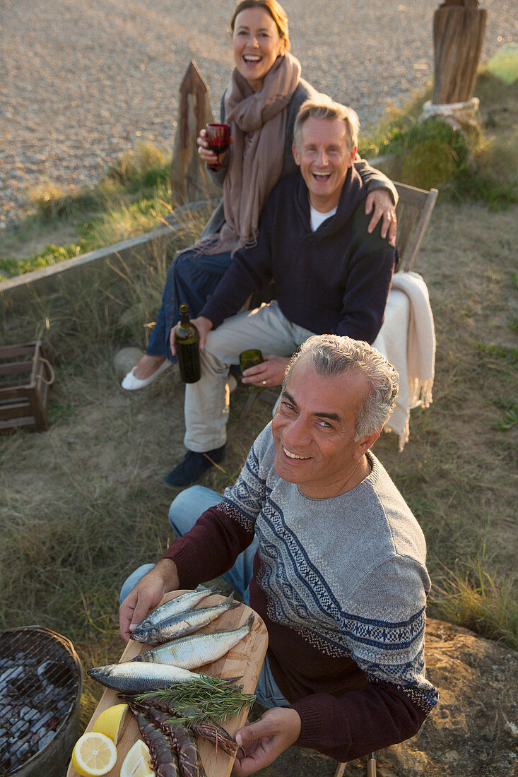 Mature friends barbecuing and drinking wine