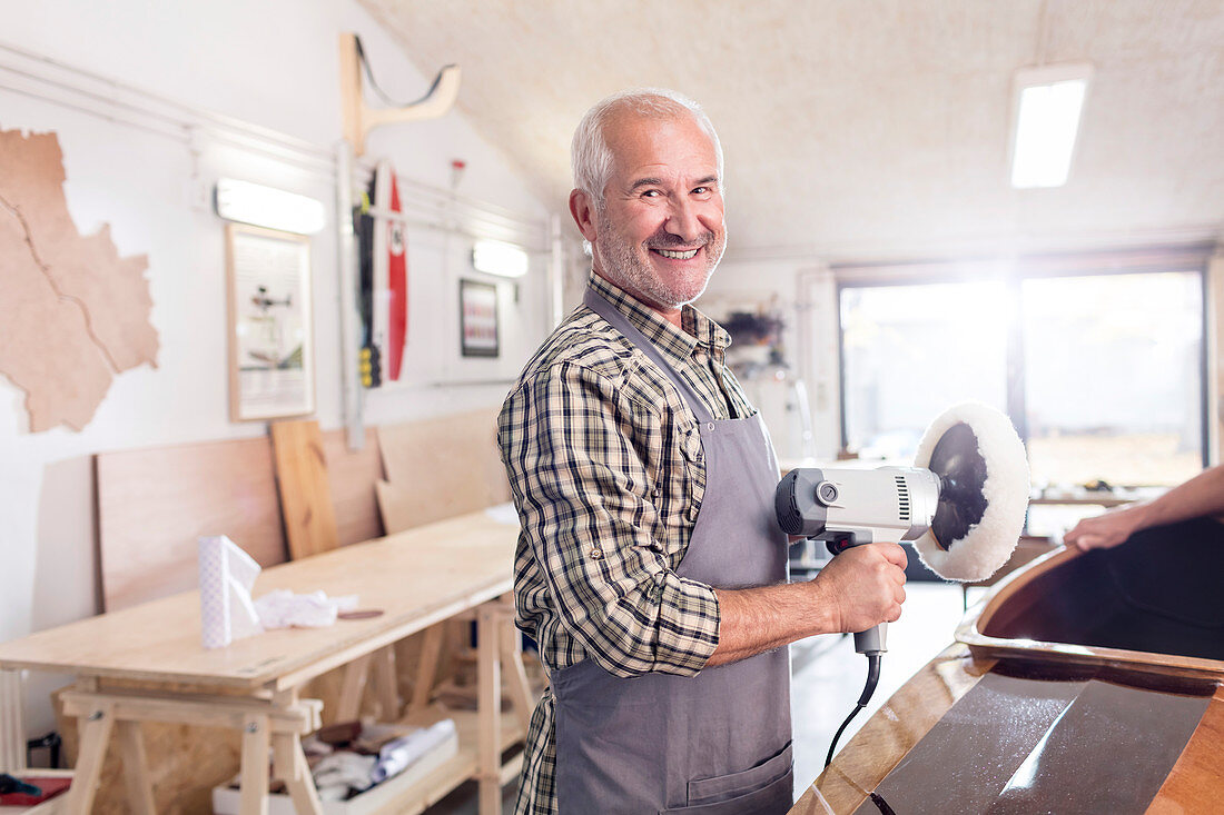 Senior male carpenter using a buffer sander