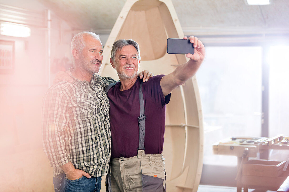 Carpenters with camera phone taking selfie