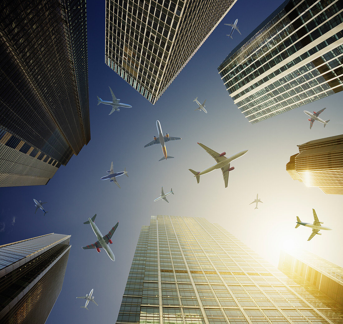 Airplanes in blue sky above highrise buildings