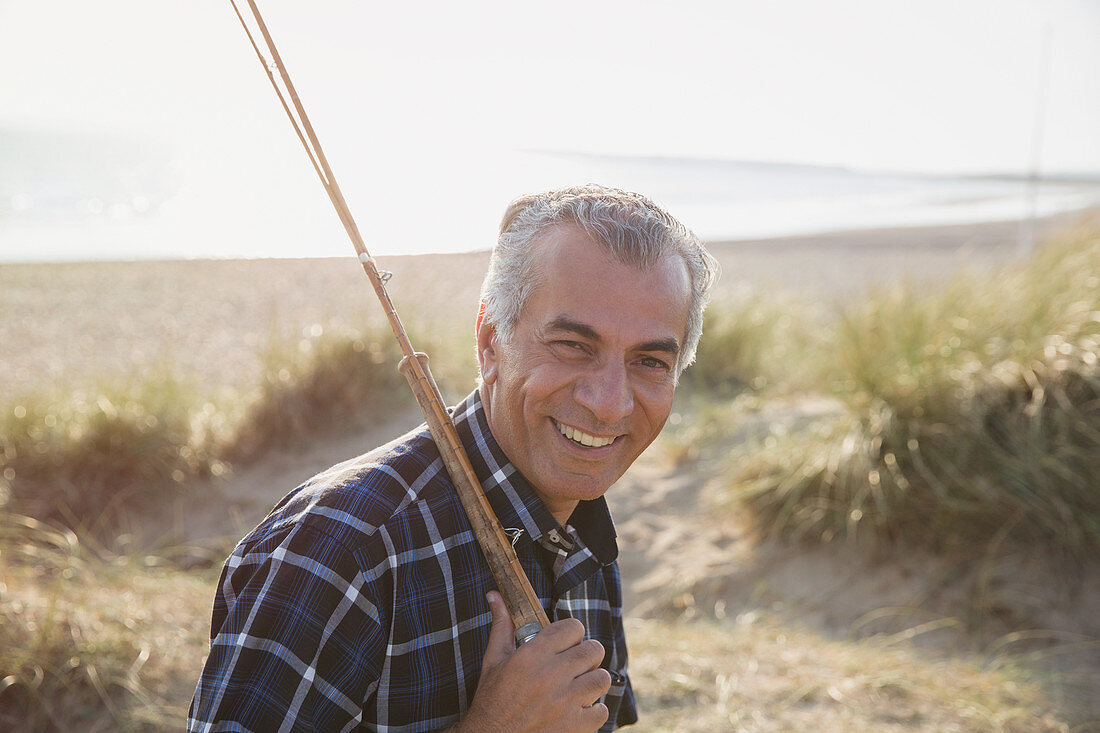 Portrait senior man with fishing rod walking