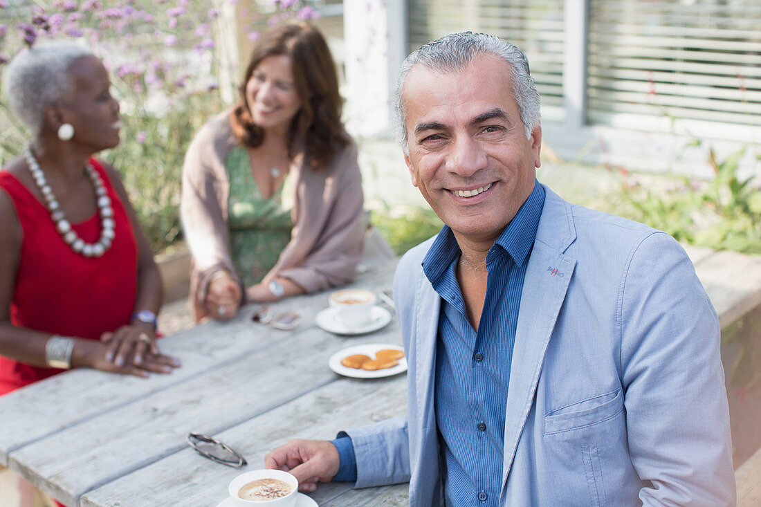 Portrait senior man drinking coffee with friends