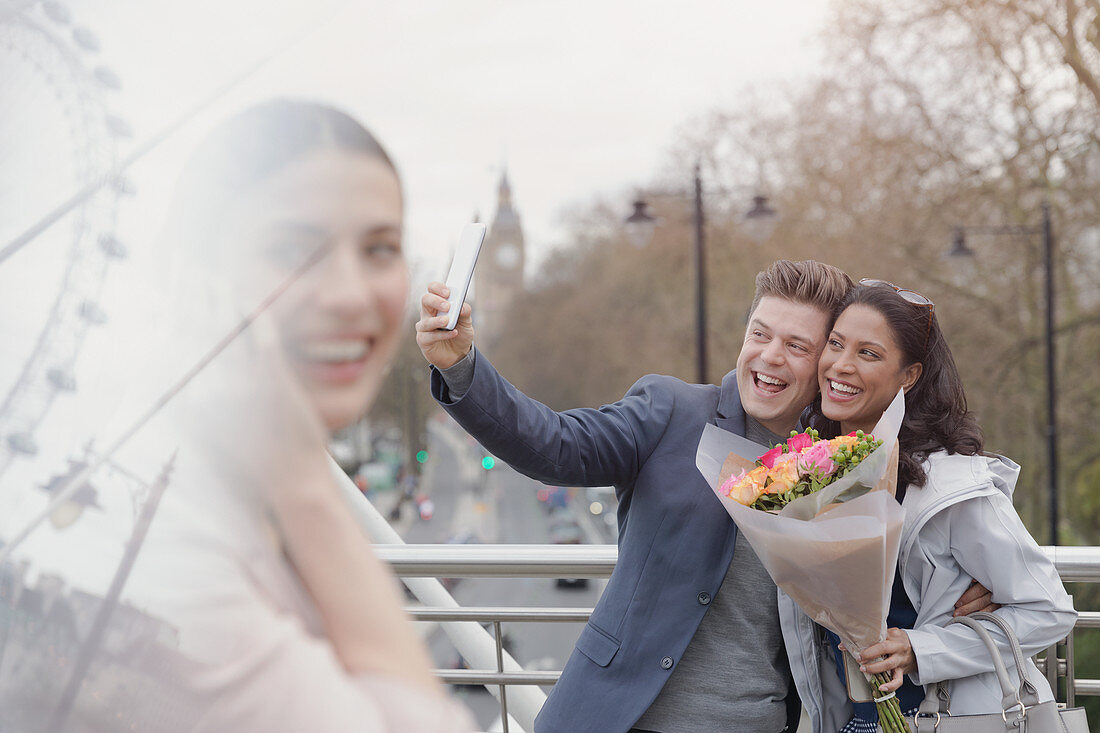 Enthusiastic couple taking selfie, London, UK
