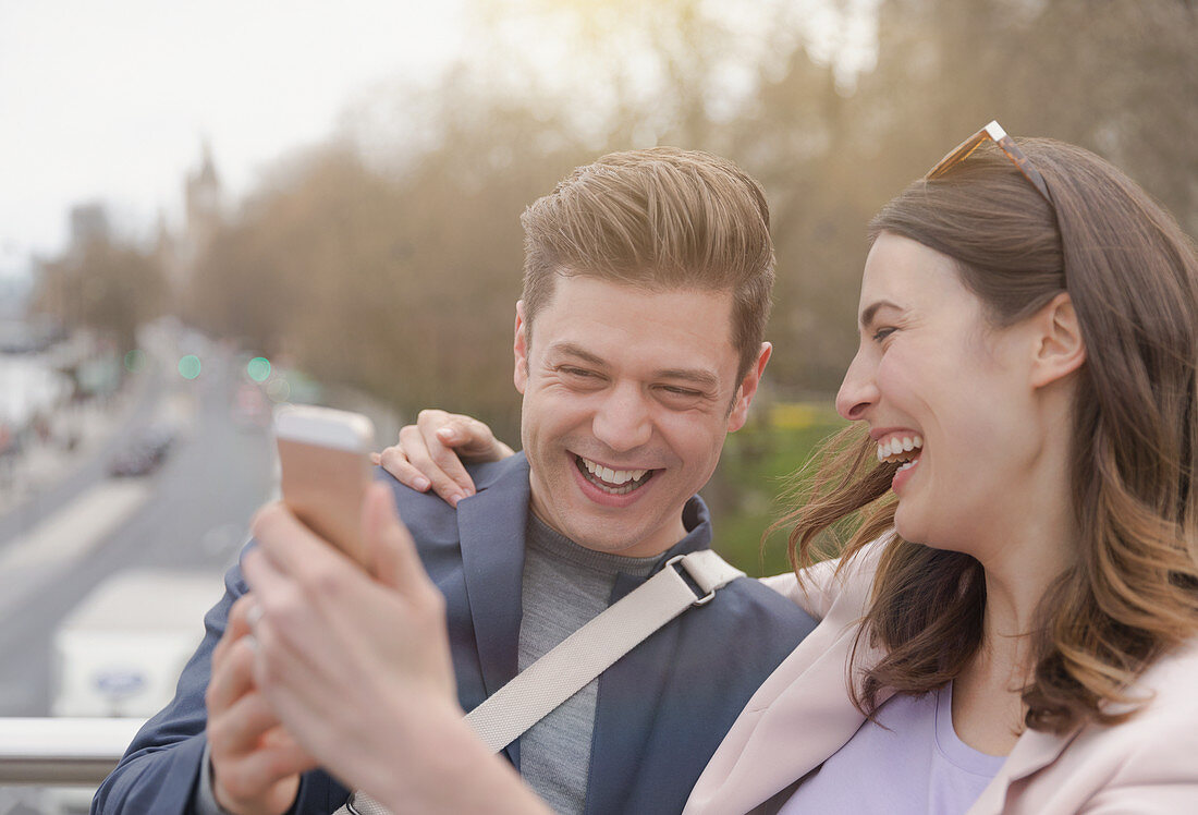 Laughing couple taking selfie with camera phone