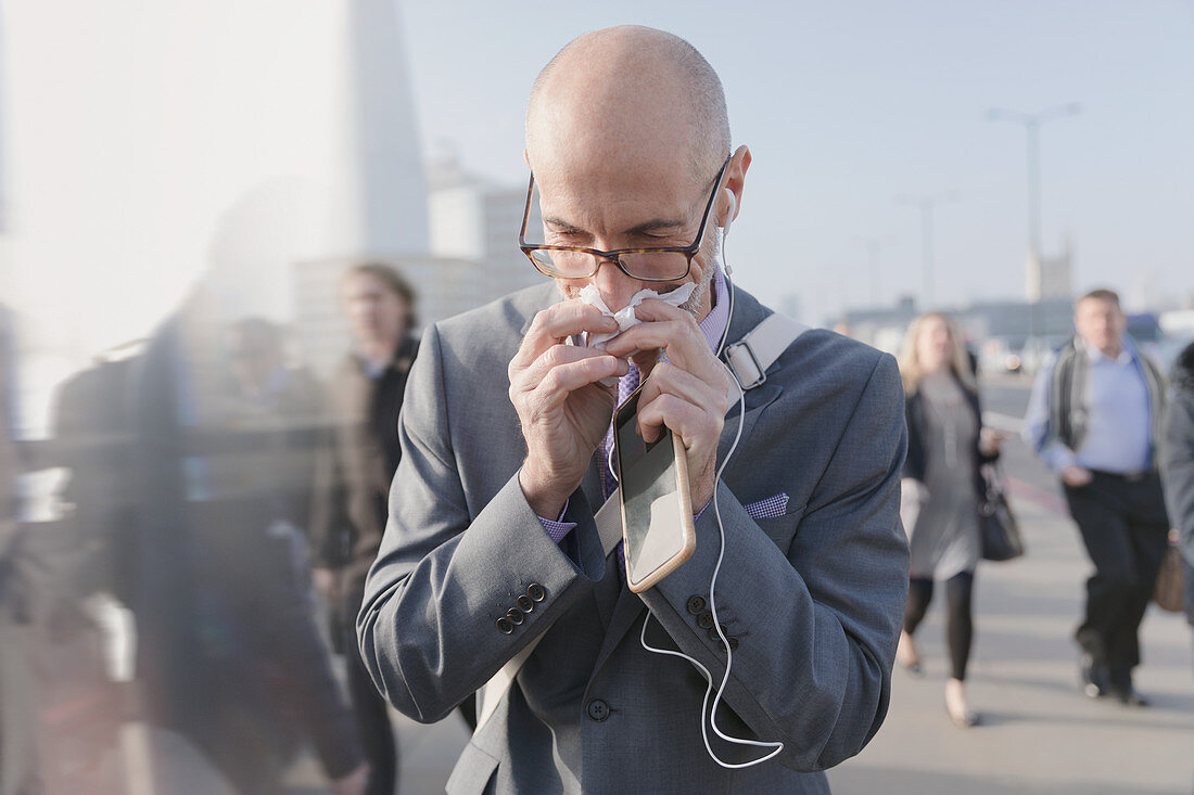 Businessman blowing nose