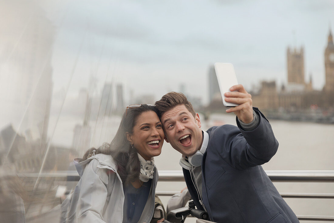 Playful couple tourists taking selfie, London, UK
