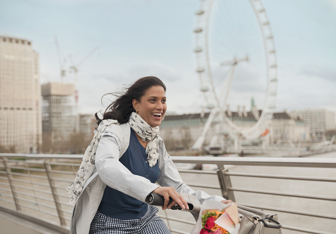 Woman bike riding on bridge, London, UK