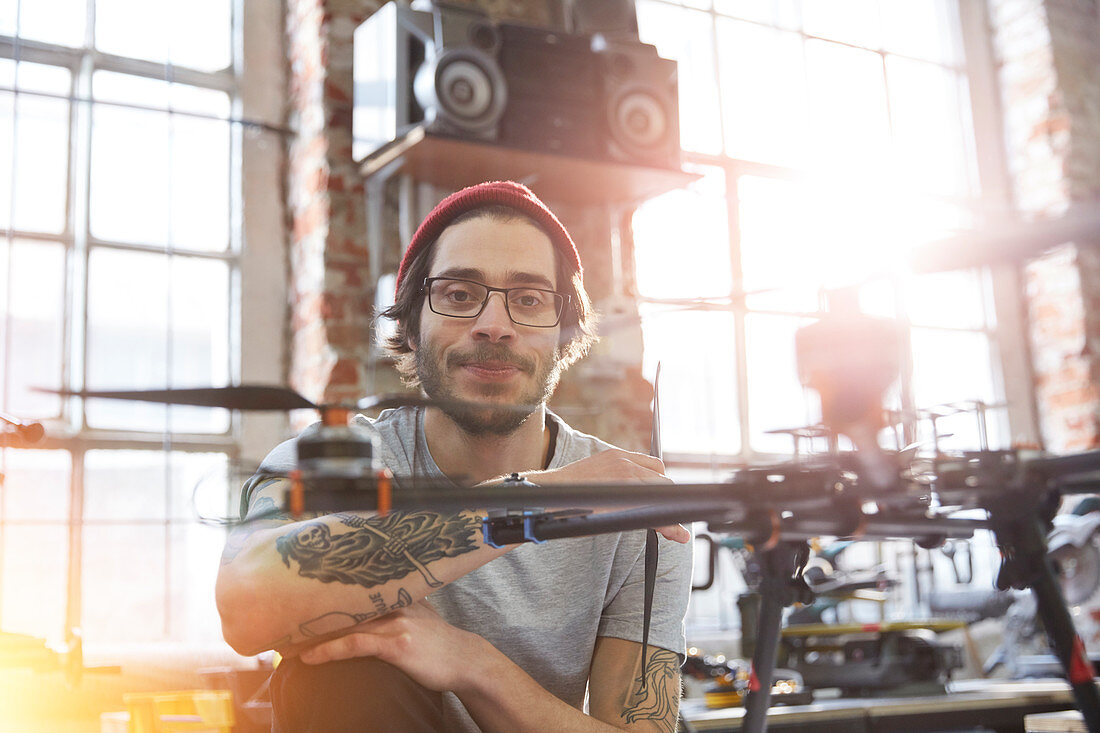 Portrait designer with tattoos working on drone