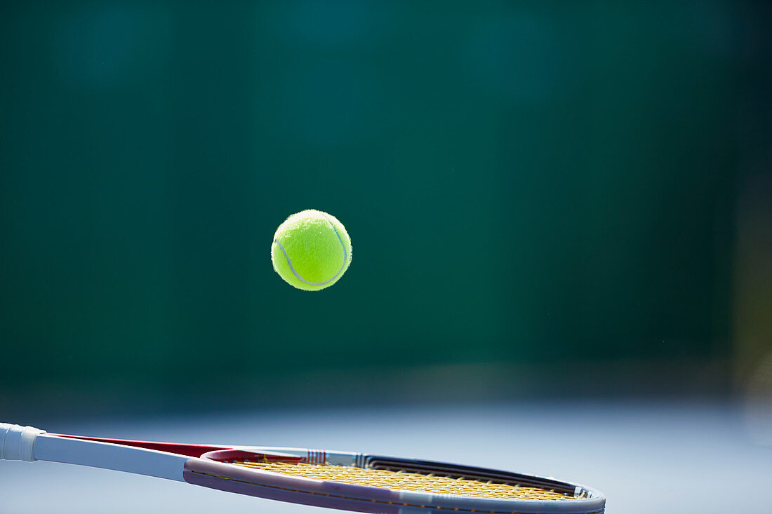 Tennis ball bouncing on tennis racket