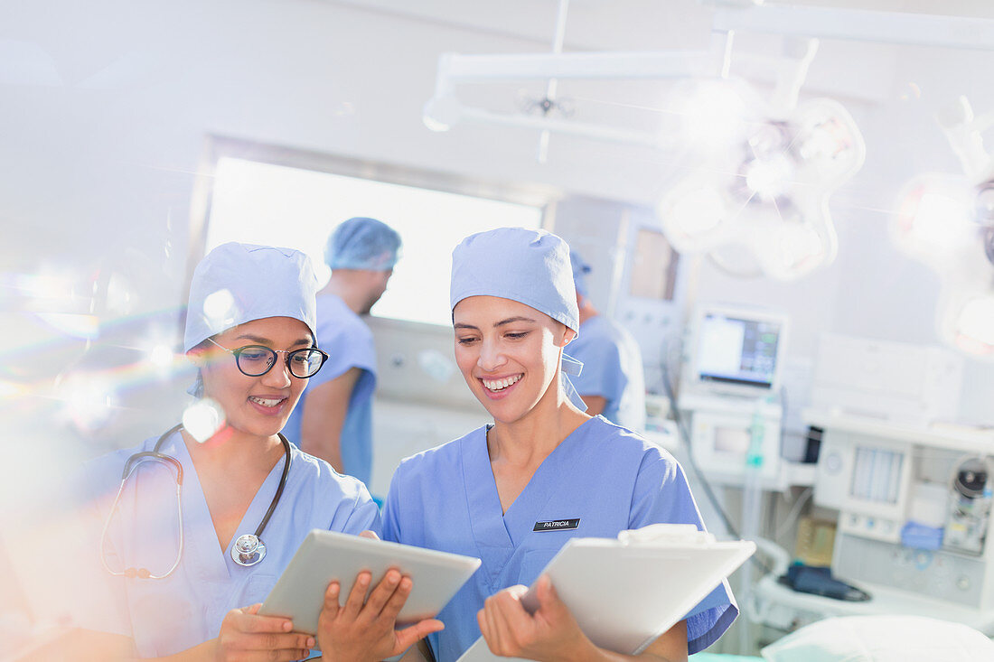 Smiling female surgeons using tablet