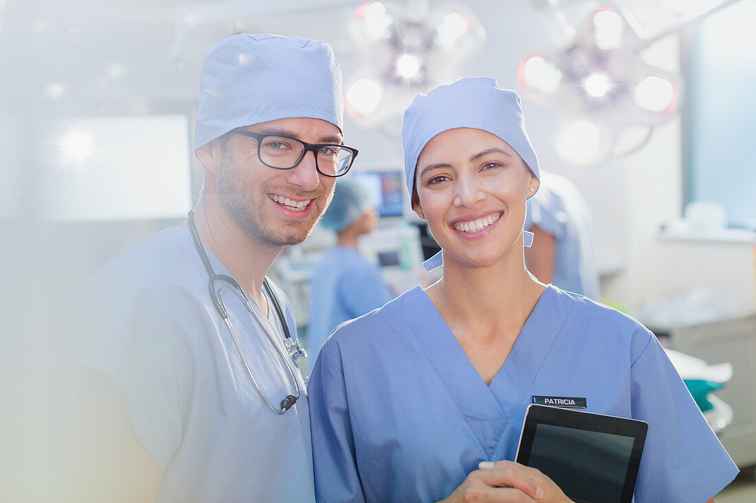 Portrait smiling surgeons with digital tablet
