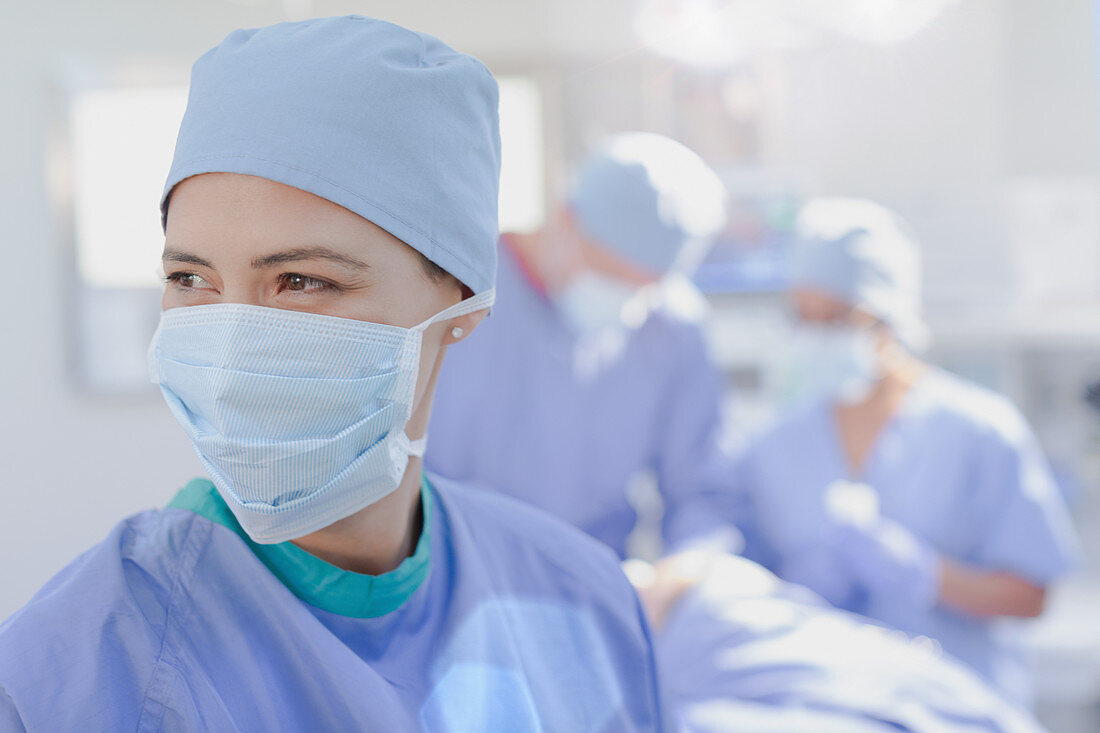 Smiling female surgeon wearing surgical mask