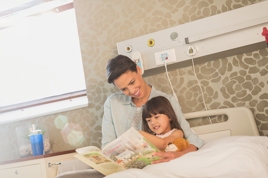 Mother reading book with daughter patient