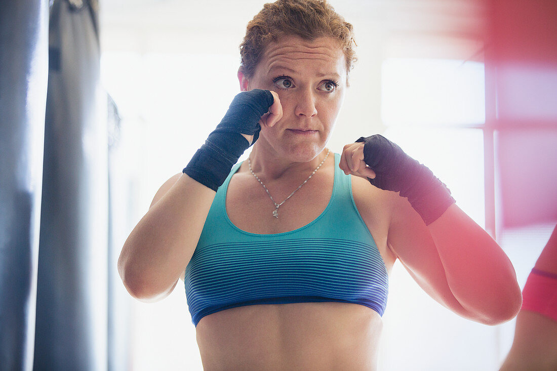 Determined boxer in fighting stance at gym